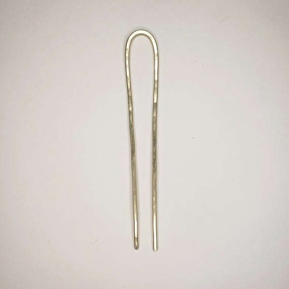 hand hammered brass hair pin, simple shape showing two prongs bent over at the top