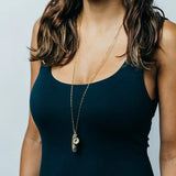 woman wearing survival necklace. showing long length and gold chain