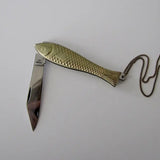 Fish knife pendant with knife halfway pulled out, light reflecting off of blade￼