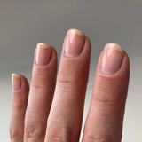 nail polish swatched on to light skin toned hand. shows light reflecting and the sheer golden shimmer of the polish