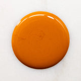 Drop of nail polish to show colour. Orange tangerine color that is bright and saturated