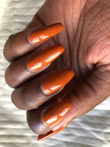Swatch of nail polish on dark skin tone hand the colour looks bright and rich