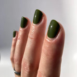 nail polish swatch on light skin tone hand, the colour is deep and saturated green￼