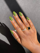 nail polish swatch on dark skin tone hand.  the colour looks bright and refreshingly green.  ￼