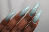 Swatch of colour on dark skin tone hand colour is bright sky blue and creamy￼