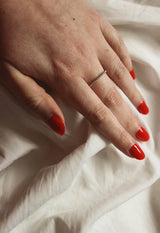 Swatch of the colour on a fair skin toned hand showing the colour to be bright and classic red￼
