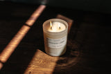 candle with both wicks lit on wooden table 