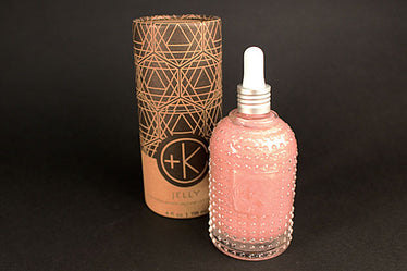 intricate glass bottle with decorative 3-D dots all around it Filled with a pink shimmery liquid￼￼