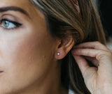 woman wearing thames earrings shows flash in opal and dainty size
