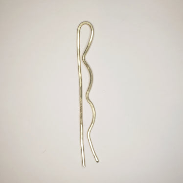 brass tone hammered hairpin on white background. the hairpin has two prongs. one with three bubble on the side to resemble a bobby pin