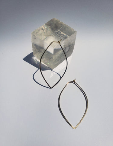 Small petal hoops one lying against crystal on neutral background