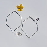 large hexagon hoops are geometric with a point at the bottom silver shape that is hand hammered
