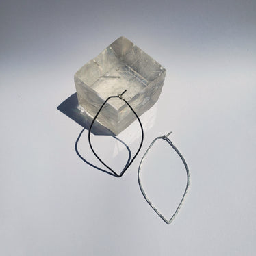 Large petal hoops laying on neutral background one laying against a cubic