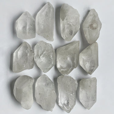 Small raw clear quartz points on neutral background