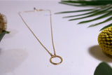 Close up of gold mini circle necklace emphasising hand hammered mini circle wrapped on to simple delicate chain