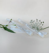 Shot of selenite sticks or neutral background showing size next to flowers