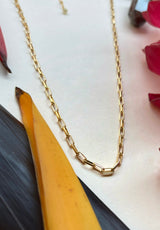 Close up details of gold chain showing slightly rounded rectangular links