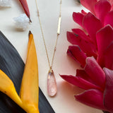 Detail shot a rose quartz teardrop pendant shows faceted light reflections