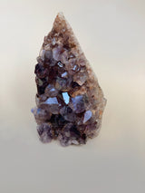 right side view of medium amethyst cluster showing deep purple tones with lighter pink peach crystal striations￼