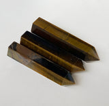 three tigers eye obelisks laying on side showing beautiful golden brown tones