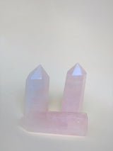 Three rose quartz obelisks on neutral background showing pink colour