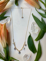 Flat lay image of pearl mixed chain necklace on a white background with flowers￼