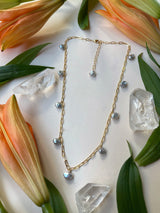 Light bouncing of flowers, chain, and pearls on white background