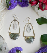 Hammered bell earrings featuring a tourmalinated quartz teardrop stone encapsulated by a hammered gold shape with a labradorite half circle hanging off the bottom￼