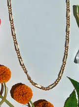 detail shot of metal chain showing beautiful gold tones and patterned rectangles in circles￼