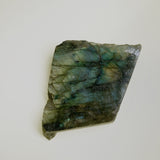 Small labradorite shape of neutral background shows rectangular shape and yellow and blue flash
