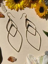 detail shot of double leaf hoops. these earrings feature too leaf shaped hammered metal hoops interlinked that catch the light beautifully￼