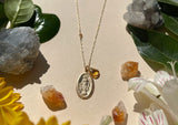 Detail shot of Saint Marys gold pendant shows oval shape and engraved Saint Mary figure