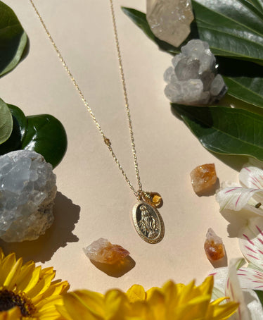 Saint Mary Stone charm necklace on neutral background with decorative flowers and crystals
