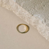 Gold ring next to slate stone or neutral background