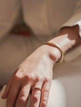 Woman wearing gold Ojai ring shows thin band with raised centre