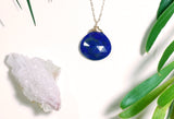 Close-up shot of lapis faceted pendant shows bright deep blue and faceted reflections