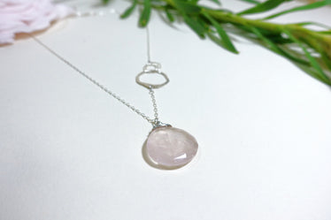 Rose quartz necklace on white background showing around rose quartz pendant and three hand hammered circles interlinked in the middle of the chain