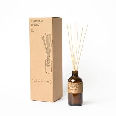 amber glass reed diffuser bottle sitting next to cardboard display box