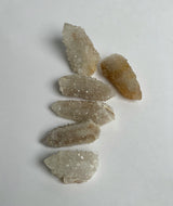 Small golden spirit quartz clusters showing light reflecting off of many points on the stone