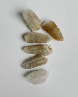 Small golden spirit quartz clusters on white background showing deep amber color and white highlights