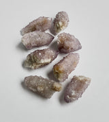 Small purple spirit quartz clusters grouped together on neutral background