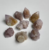 Close-up shot of small spirit quartz clusters showing purple and Amber tone and light reflecting qualities