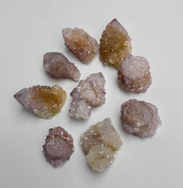 Mini purple spirit quartz clusters about an inch long on a white natural background