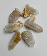 Golden spirit quartz cluster points close-up shot showing glitter like light reflections and white golden tones