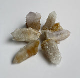 Six Golden spirit quartz cluster points in a circle on a neutral background