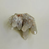 Mineral cluster of grey tone on neutral background showing light reflecting qualities and lavender undertones