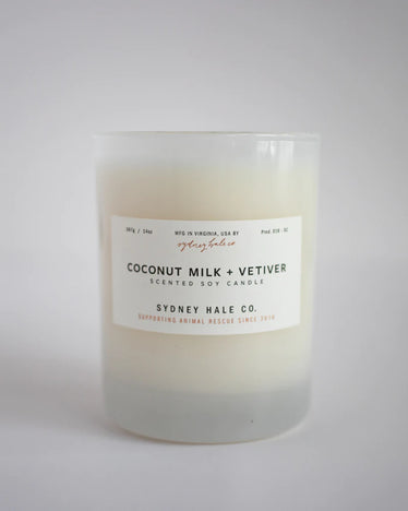 Cream coloured candle in frosted white glass jar with white label