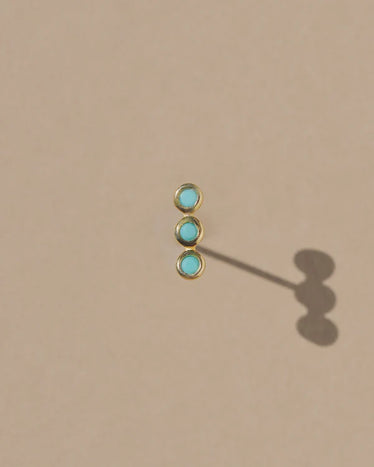 close up shot of tagus stud showing three turquoise round stones set in a straight line 