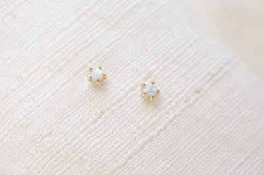 two small opals studs on linen background 