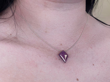 woman wearing necklace showing amethyst kite shaped stone on dainty silver chain